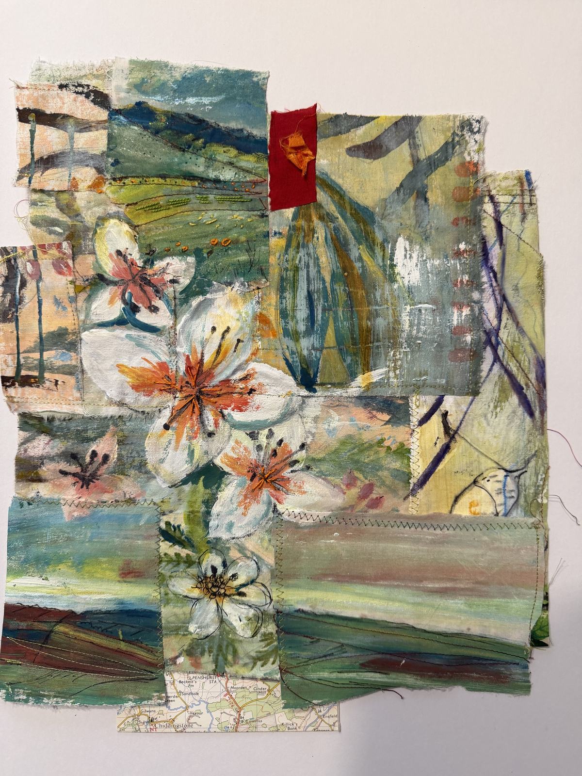 Layered textile collage with flowers, landscape fragments and visible machine stitching